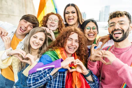 A happy group of people making heart gestures with their hands