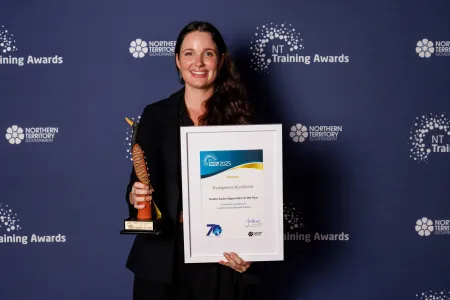 Evie stands with award