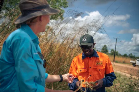 Lecturer hands native grass to First Nations student 