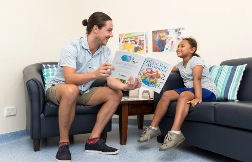 Social work student reading a book to a child